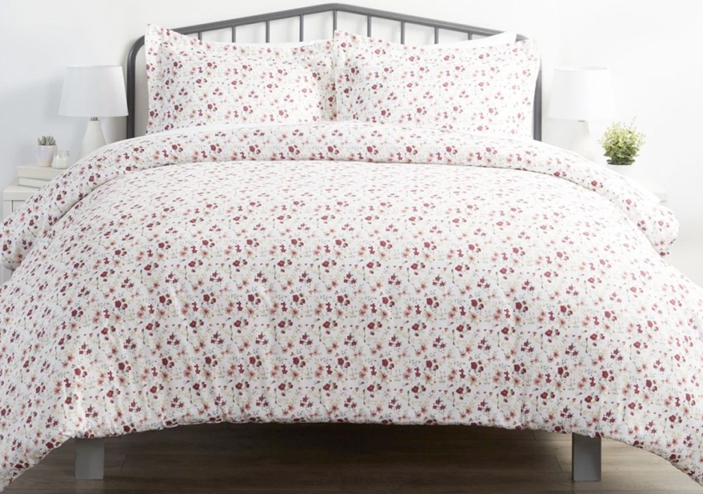 white duvet cover with pink flower pattern on bed with matching pillow shams