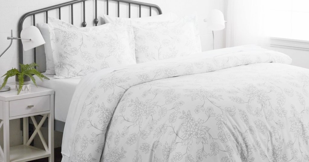 white duvet set with grey floral pattern and two matching pillow shams on bed