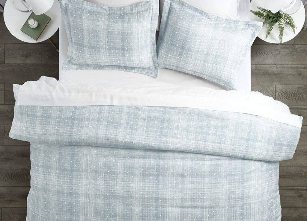 light blue and white duvet with small white dots with two matching pillow shams on bed