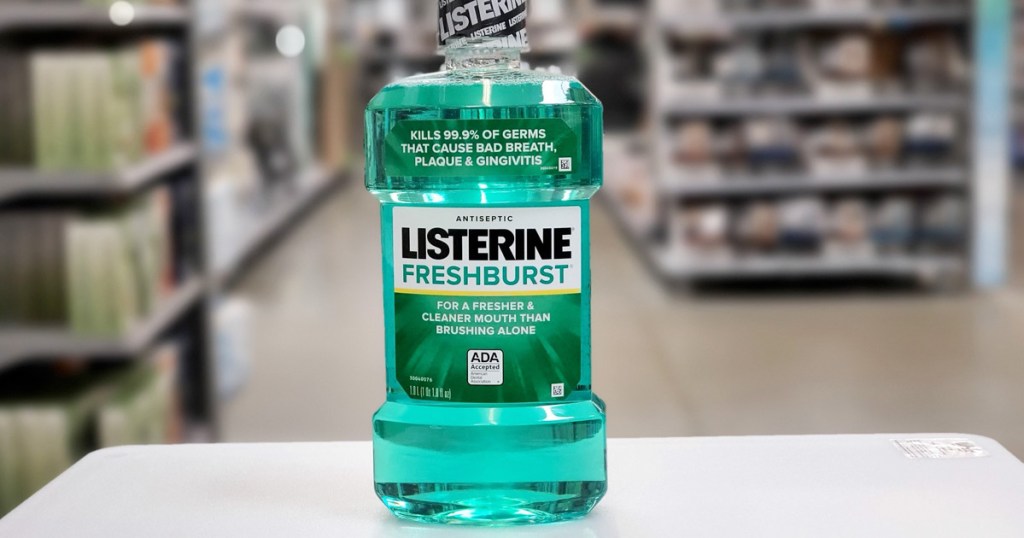 bottle of green Listerine Fresh Burst mouthwash sitting on white table