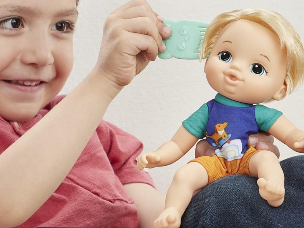 boy brushing hair on blonde doll