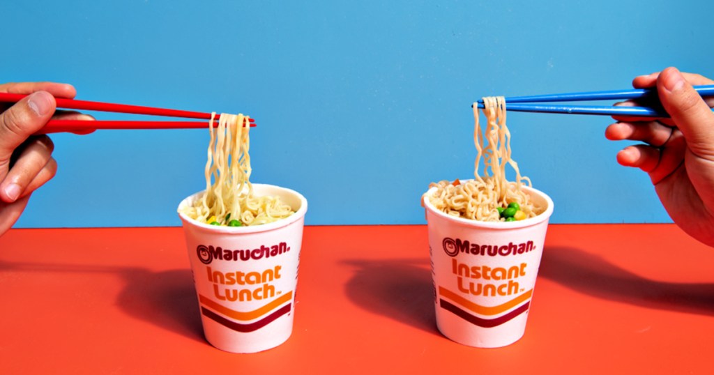 Maruchan Instant Lunch Cups of Noodles with hands using chopsticks to lift noodles