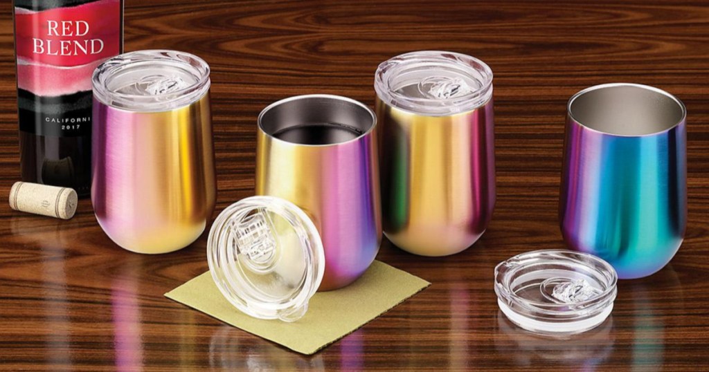 reflective rainbow colored insulated wine tumblers and bottle of red wine on wood table