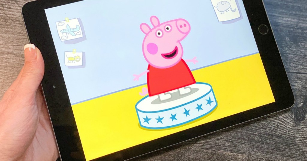 hand holding an ipad showing a peppa pig game
