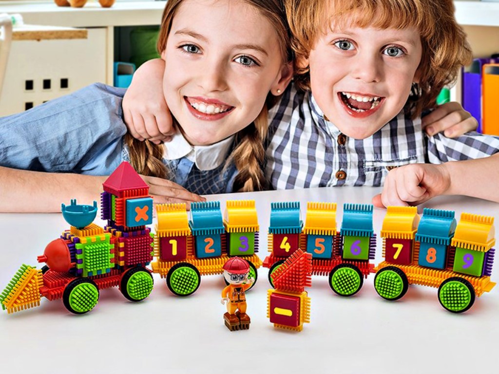 kids playing with Picasso Tiles 103-Piece Bristle Train Building Set