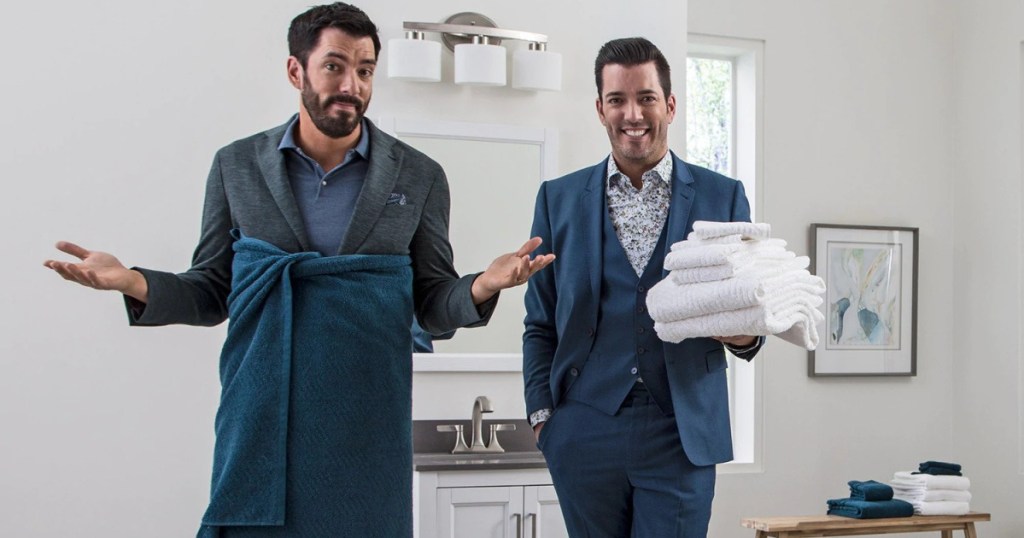 property brothers with blue bath towel wrapped around and other brother holding white folded towels