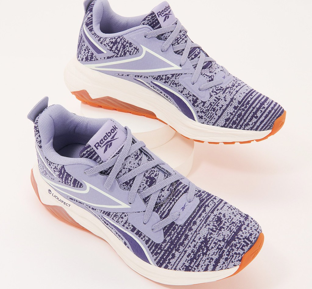 purple pair of reebok running shoes with knit mesh tops