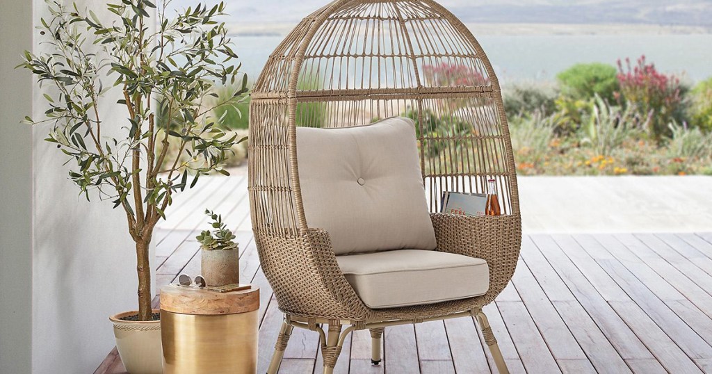 wicker egg shaped chair with cushions on deck