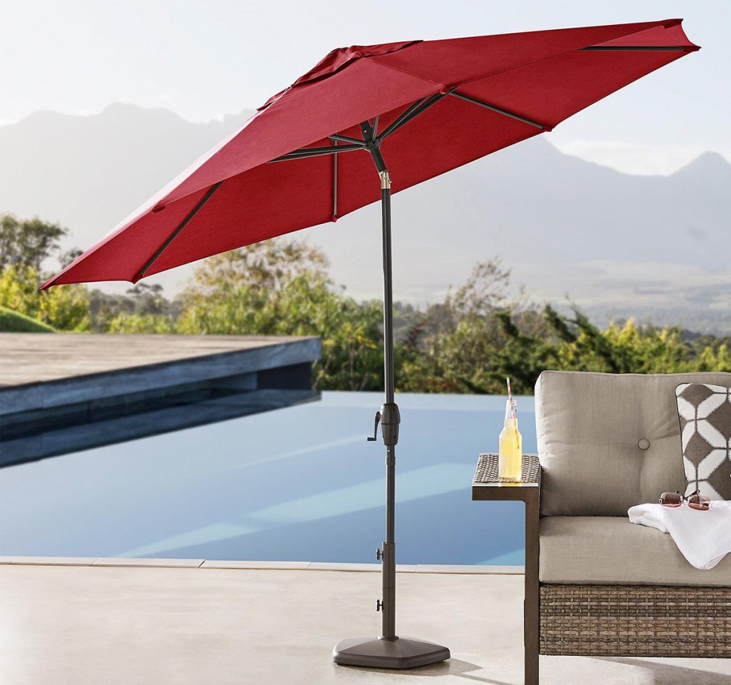 red tilting patio umbrella in backyard near pool