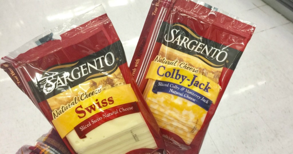 hand holding two packages of cheese slices