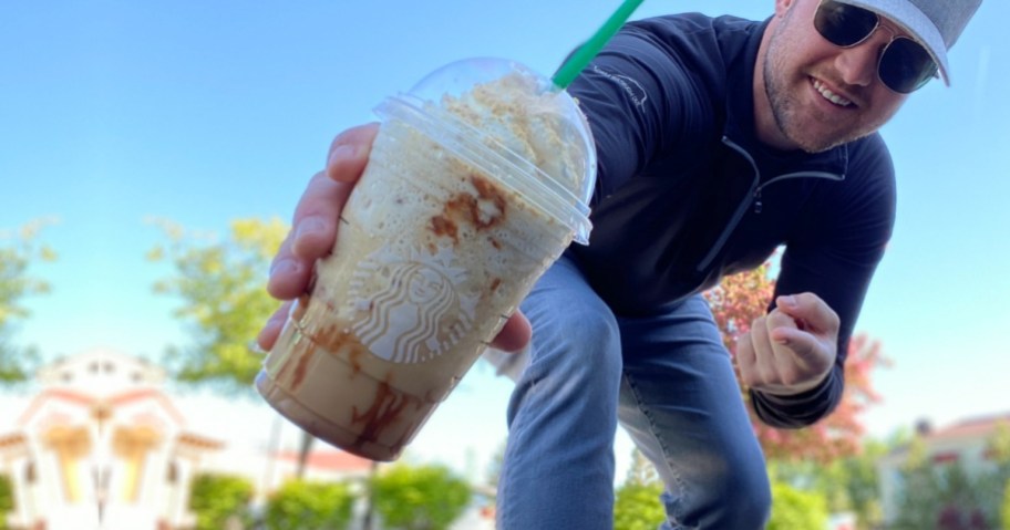 man pointing at a Starbucks drink
