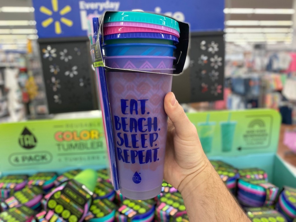 man hand holding tal patterned cups in front of display at Walmart