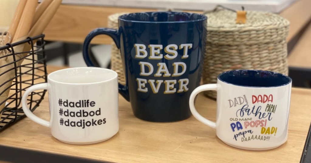 three Father's Day themed mugs on table in store