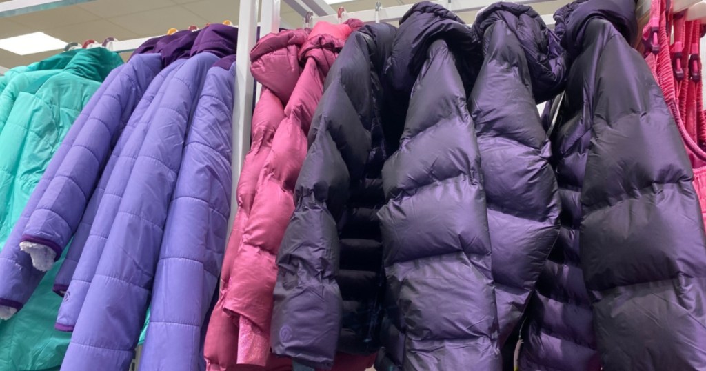blue, purple, and pink winter coats handing in store
