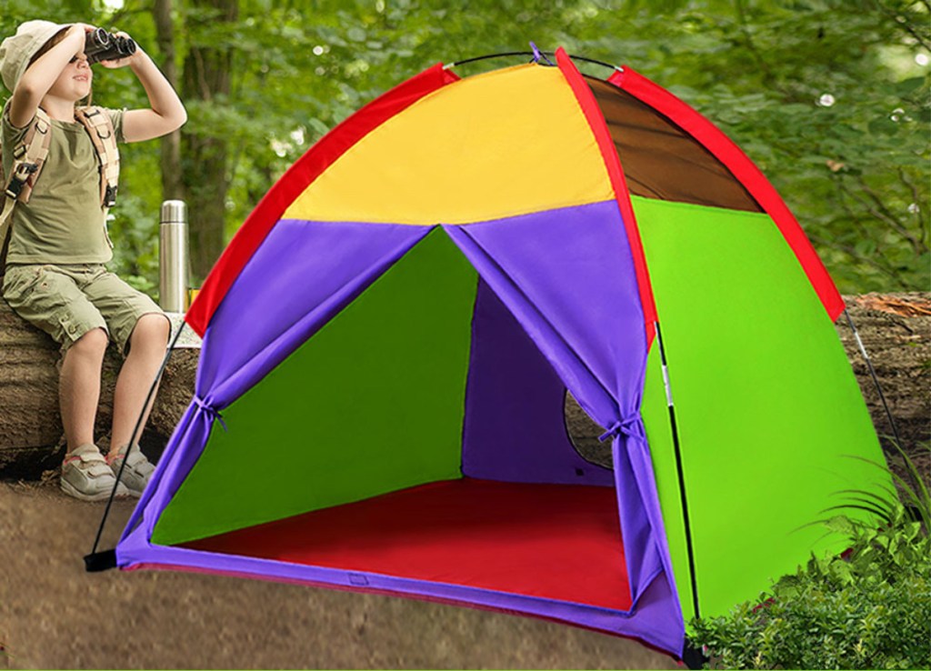 child using binoculars outside next to colorful tent