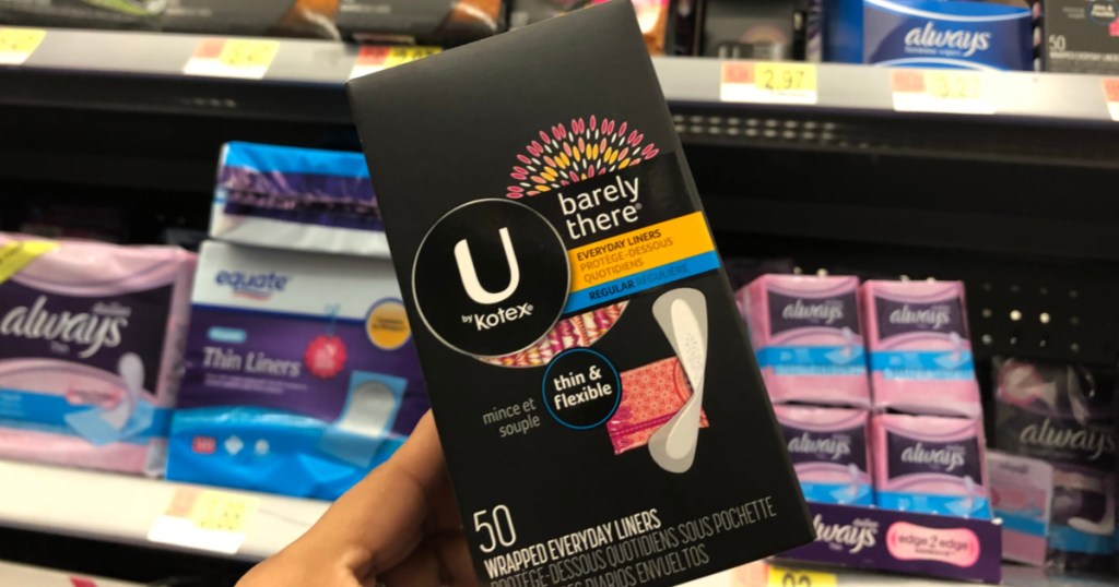 hand holding box of 50 panty liners in store aisle