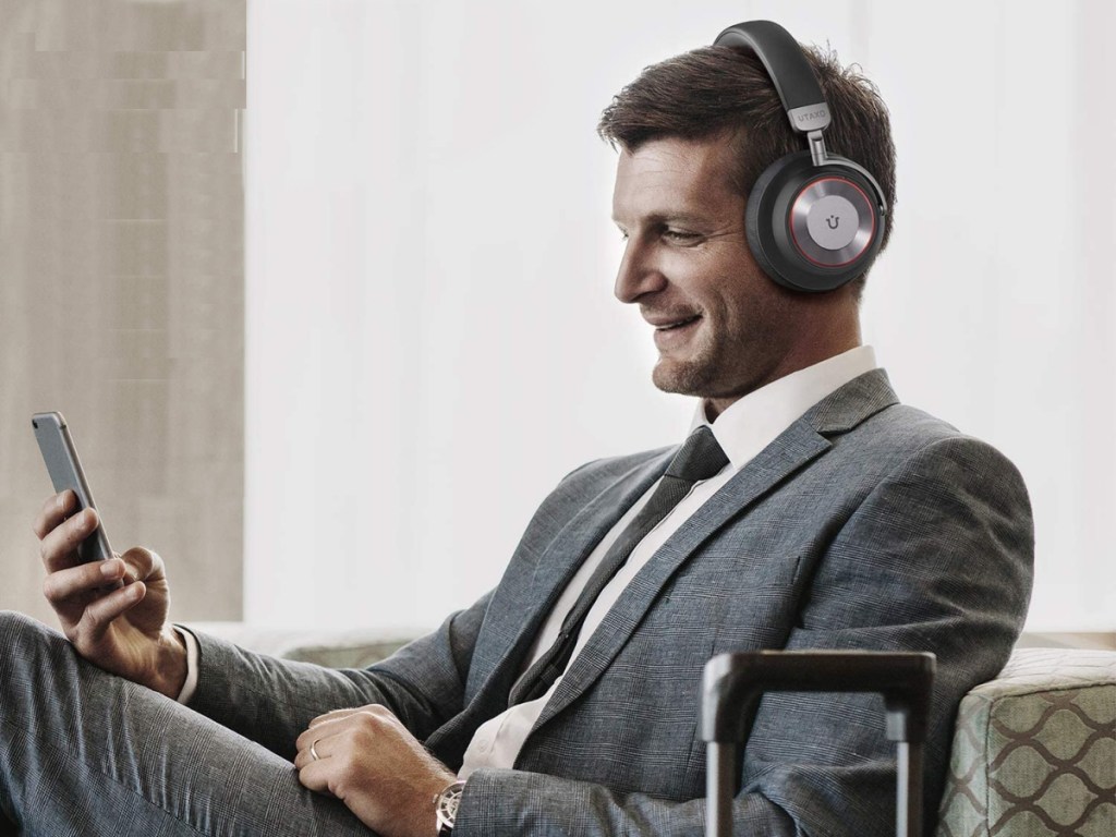 man wearing Utaxo Bluetooth Noise Cancelling Headphones sitting in chair on phone