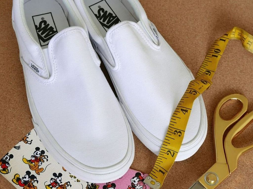white slip on sneakers next to scissors and fabric