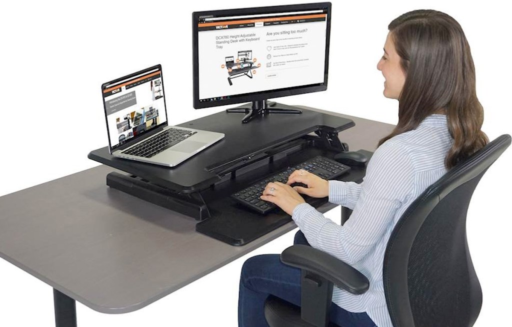 woman sitting at adjustable standing office desk