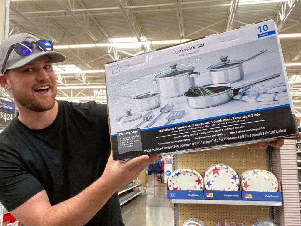 man holding up a large box of Mainstays cookware at walmart 