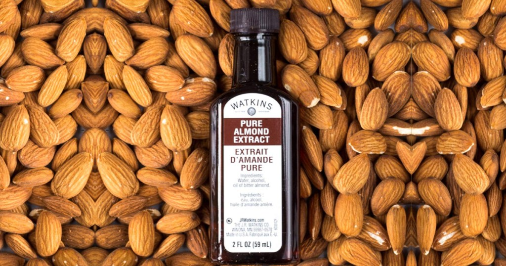 bottle of Watkins Pure Almond Extract on a bed of almonds