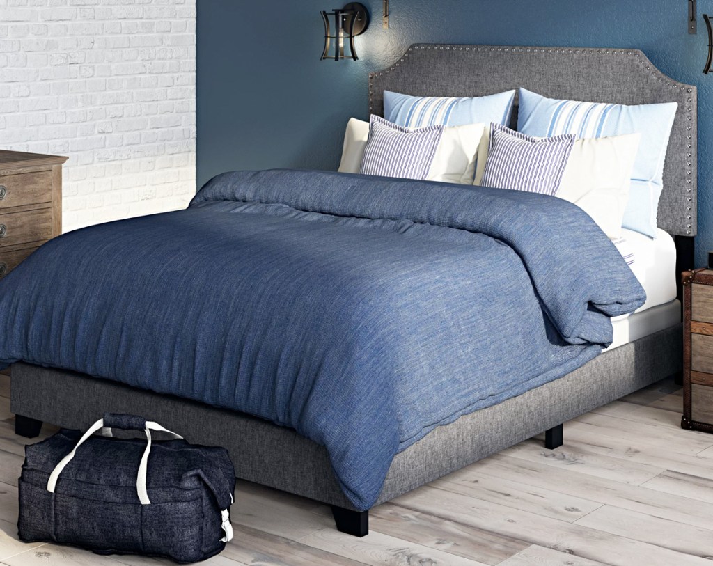 dark grey upholstered headboard and bed frame with navy blue bedding on bed