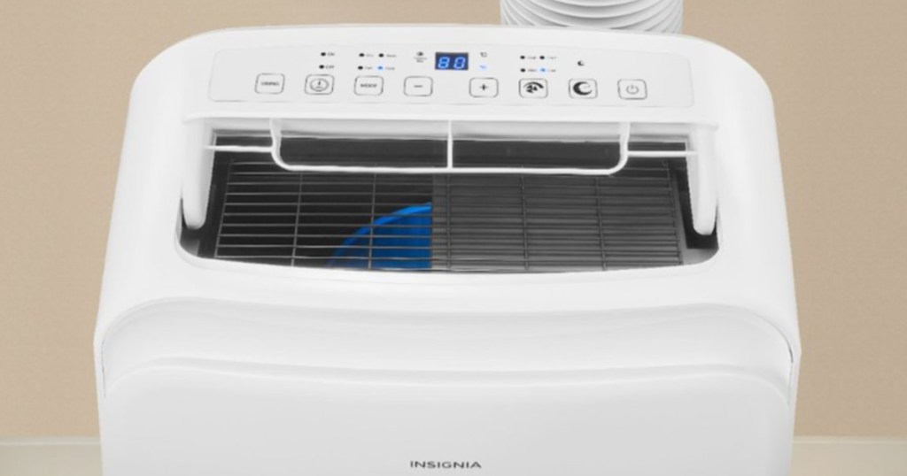 white insignia air conditioner sitting next to a tan wall