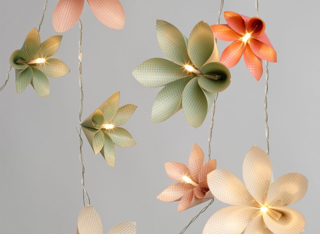 string lights with colorful origami flowers around each bulb
