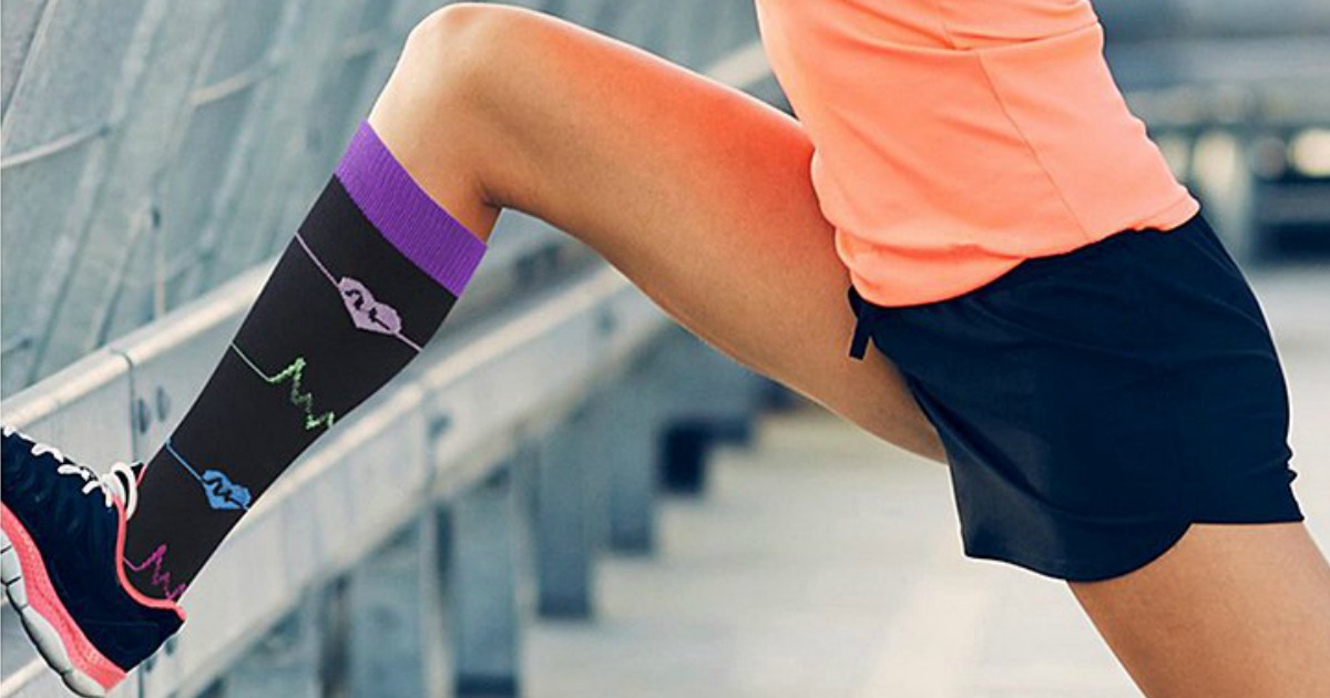 woman stretching while wearing socks with medical symbols printed on them