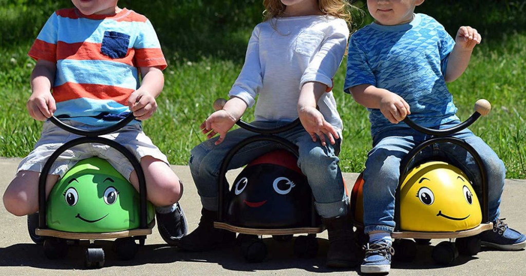 kids sitting on grasshopper, ladybug and bumble bee riding toys