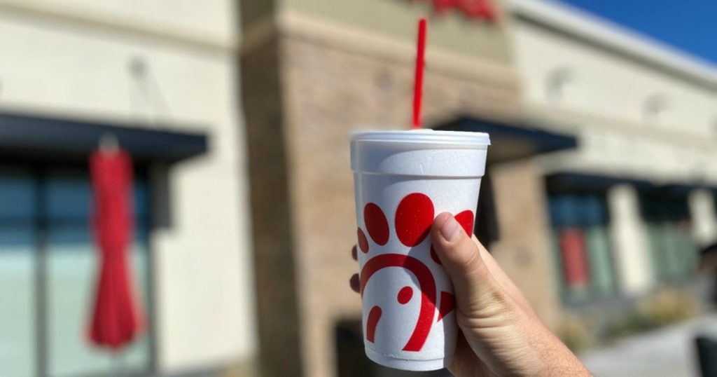 hand holding chick-fil-a styrofoam cup outside of restaurant