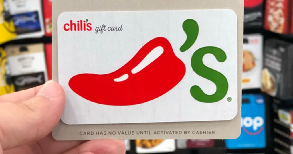 person holding up a white chili's gift card with a large red and green pepper on it