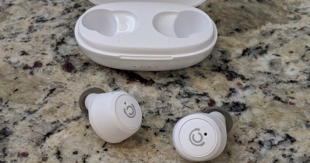 charging pod with earbuds next to it on counter