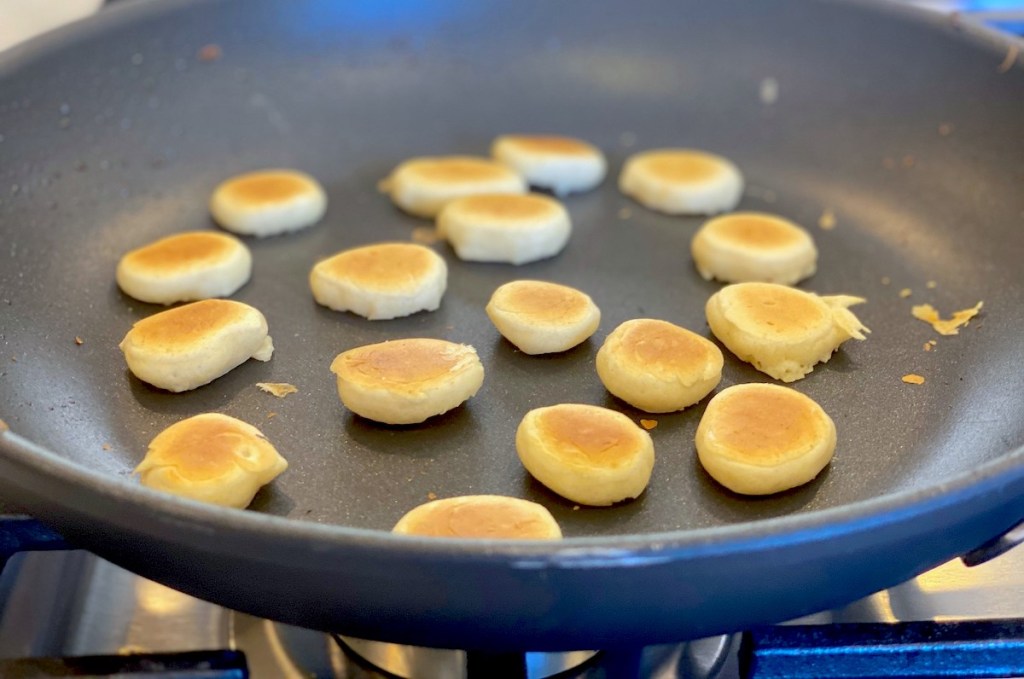 mini cooked pancakes on black pan 