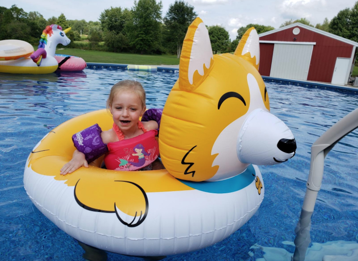 toddler girl sitting in dog pool float