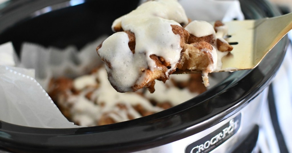 Taking monkey bread slice out of Crockpot with spatula 
