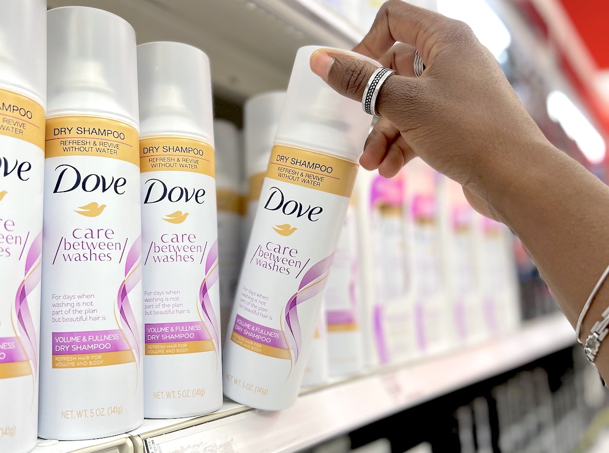 hand taking dove dry shampoo off store shelf