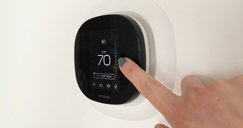 finger adjusting ac temperature on ecobee smart thermostat