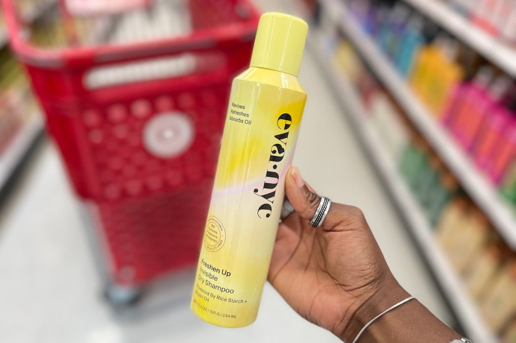 hand holding yellow bottle of best dry shampoo in target store