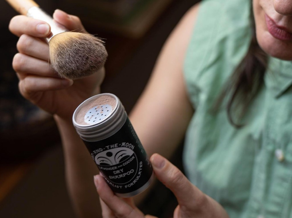 fat and the moon dry shampoo tin with woman putting makeup brush on top