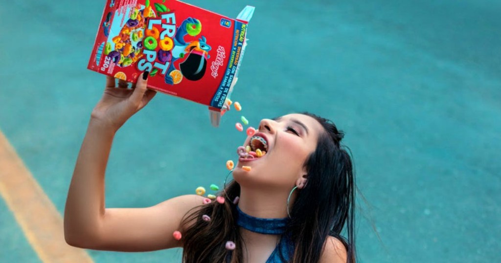 woman pouring Froot Loops cereal in her mouth on tennis court