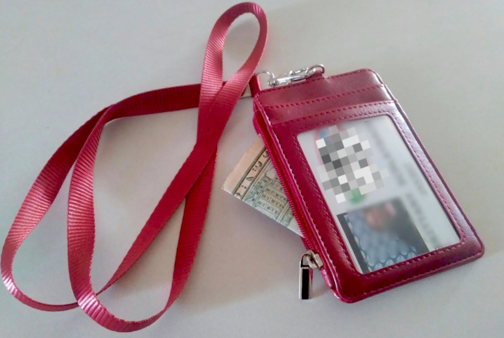 hot pink leather lanyard wallet on table with id and money