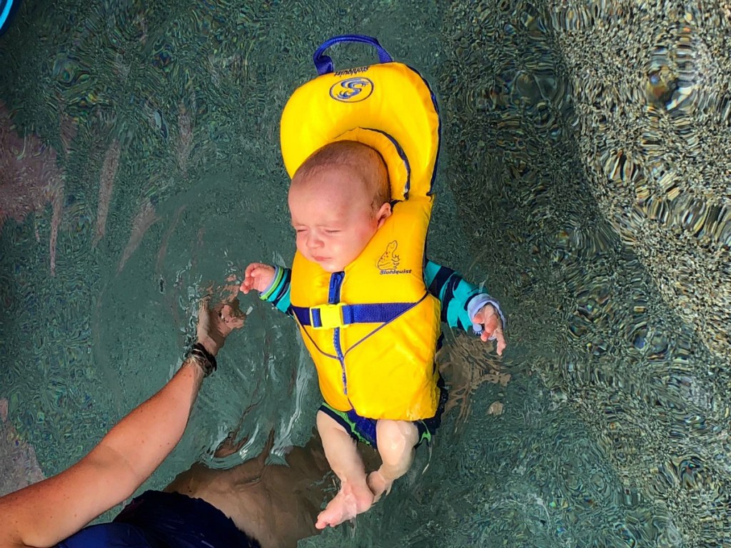 baby wearing life jacket in pool