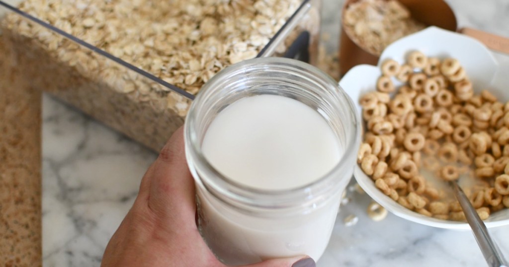 jar of homemade oat milk next to cereal 