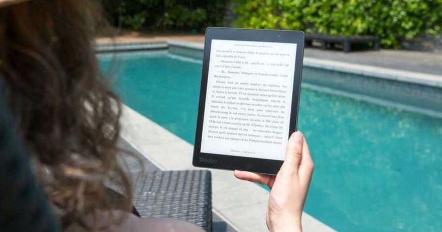 woman looking at kindle by the pool