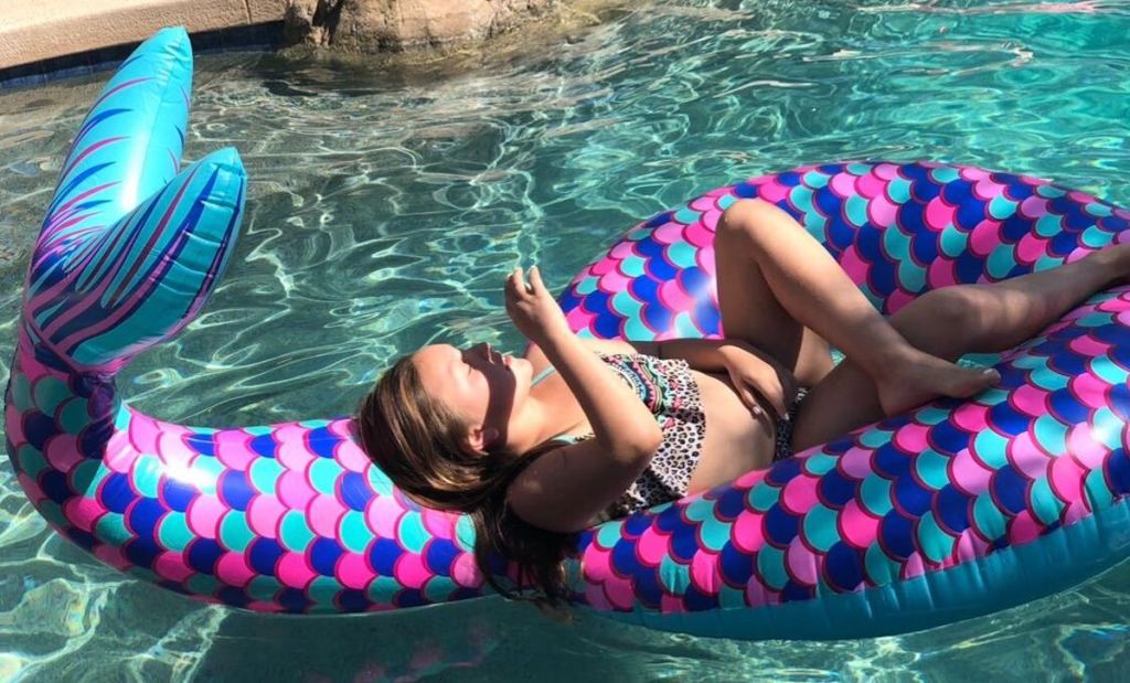 girl laying in mermaid pool float
