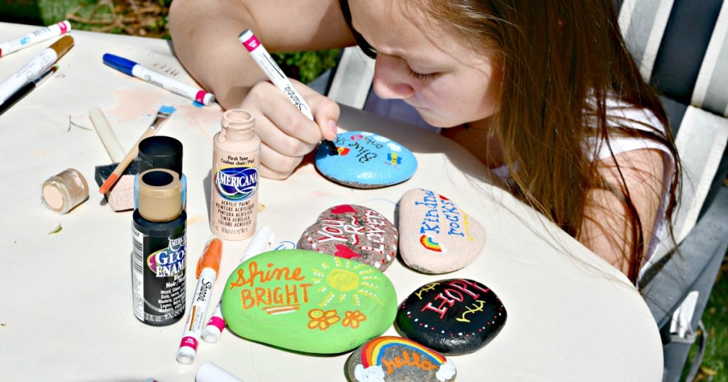 girl painting kindness rocks