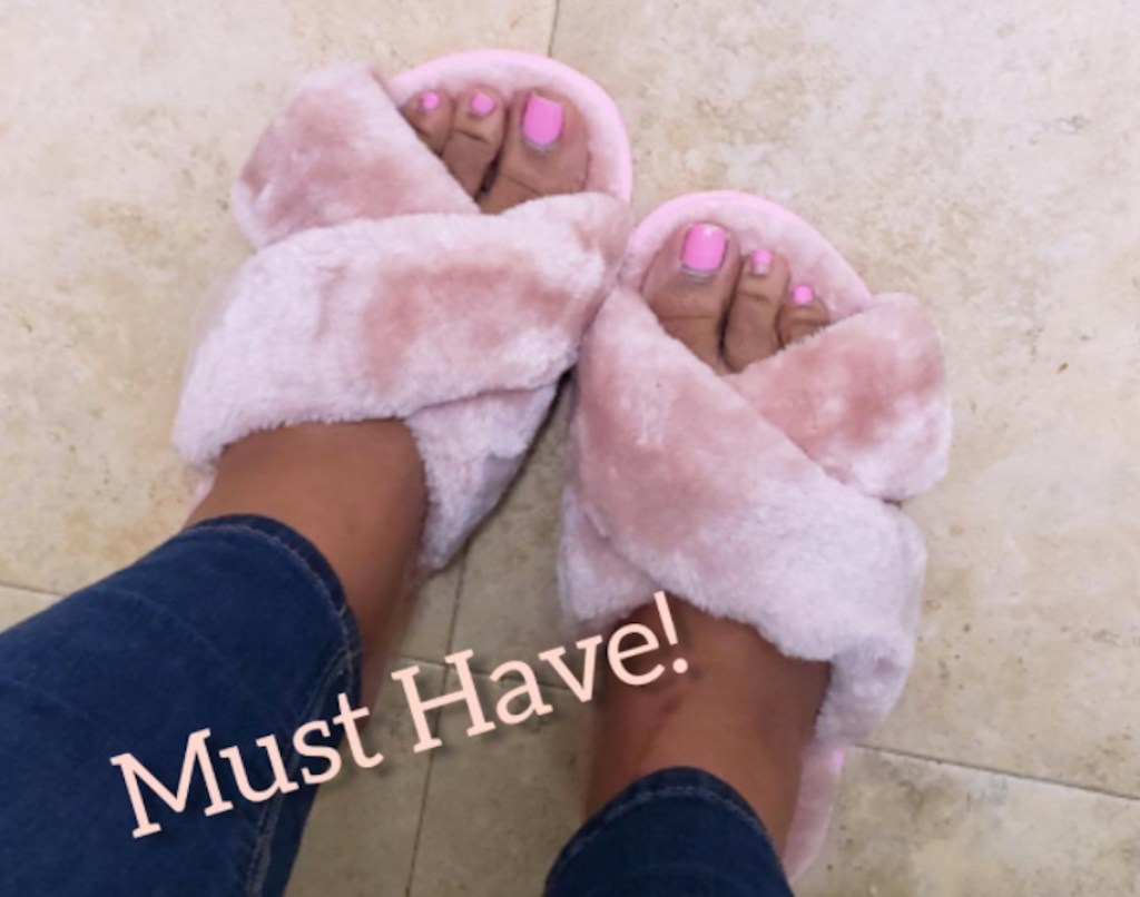 feet wearing fuzzy pink slippers with words must have on photo