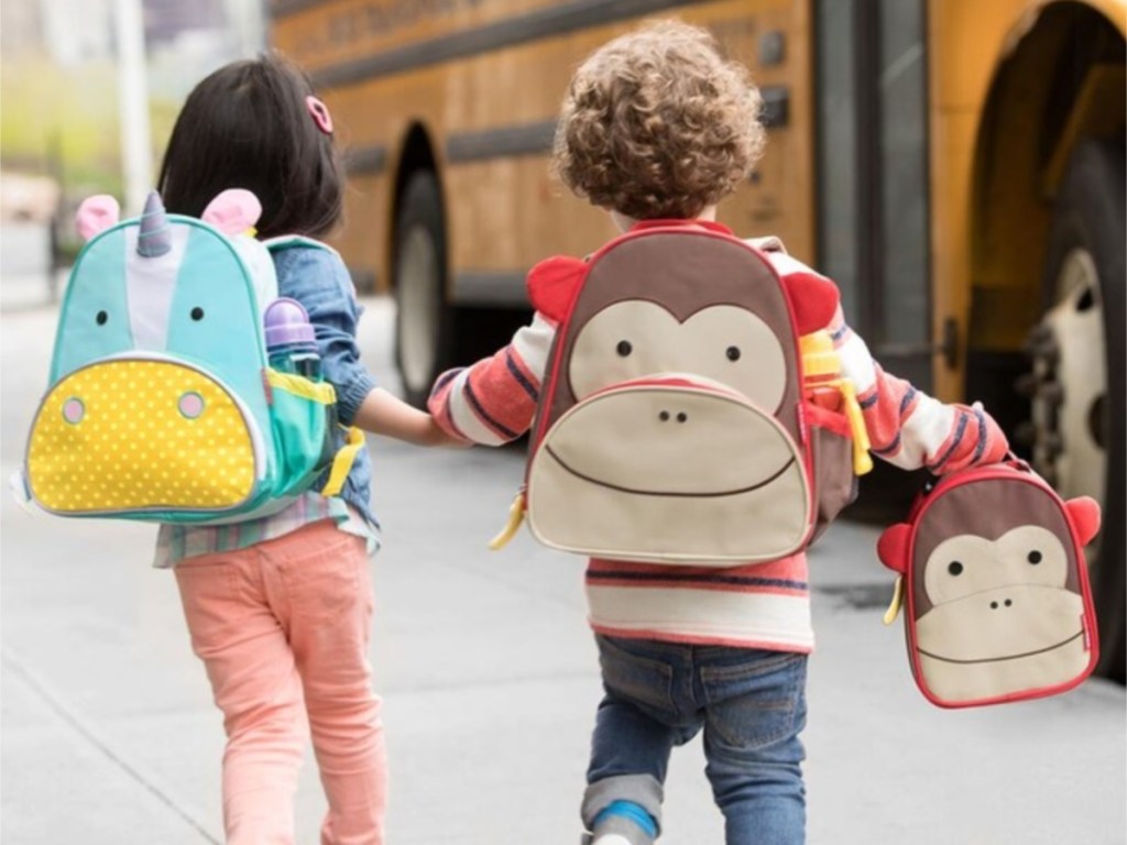 girl and boy wearing animal bookbags and boy carrying monkey lunch bag