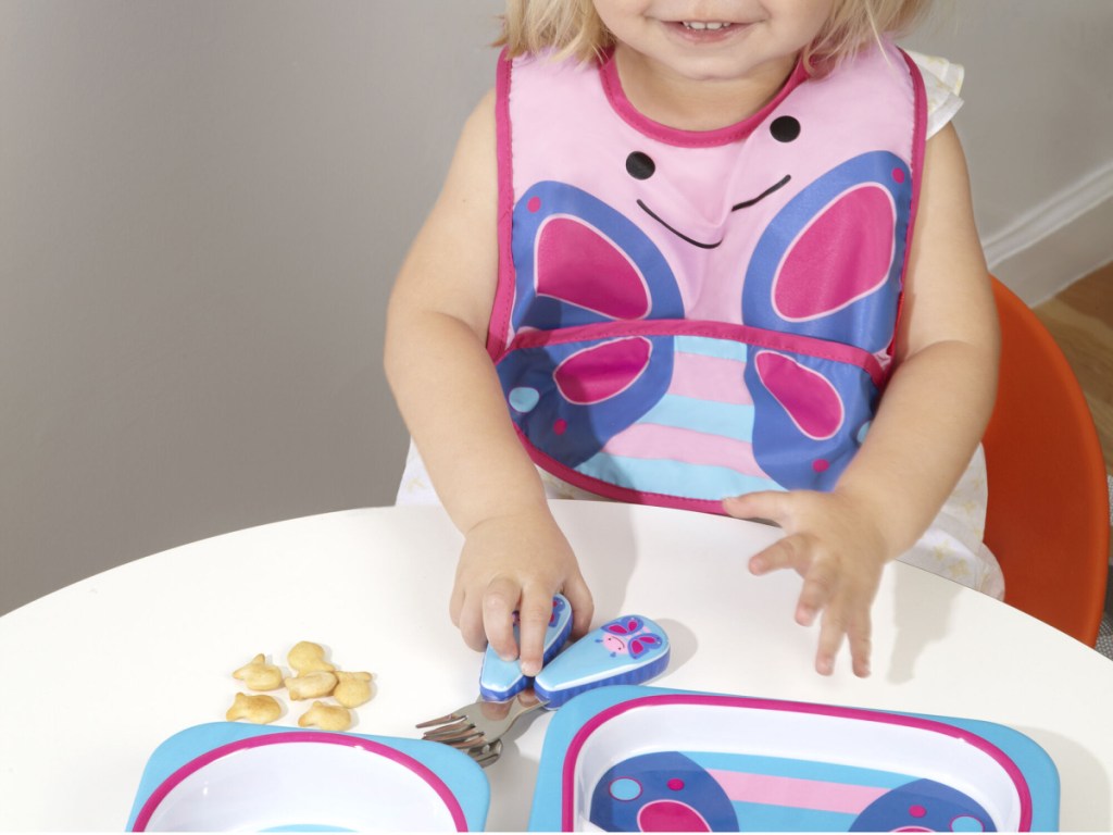 toddler girl eating with butterfly fork and spoon